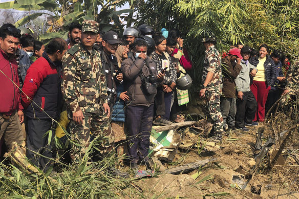 Locals and rescuers at the site of the crash near Pokhara International Aiport.