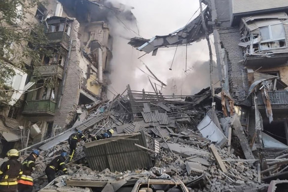 Rescuers work at the scene of a building damaged by shelling in Zaporizhzhia, Ukraine.