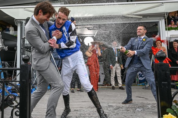 Jockey Mark Zahra is sprayed with champagne after winning the Cup aboard Gold Trip. 