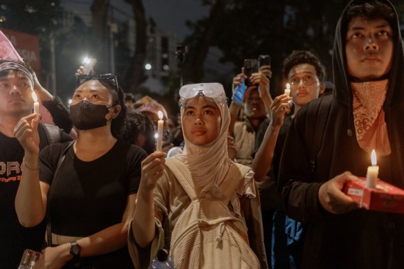 Os manifestantes seguram velas durante um protesto contra Subianto, perto do Palácio Presidencial, em Jacarta.