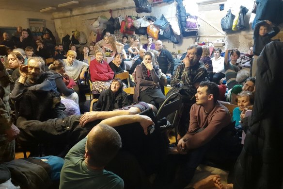 Residents of Yahidne inside the basement of a school, a day after Russian troops left. Nadiya is the seated woman in the red jumper.