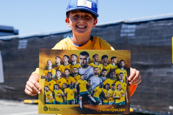 A young fan shows off his Socceroos poster.