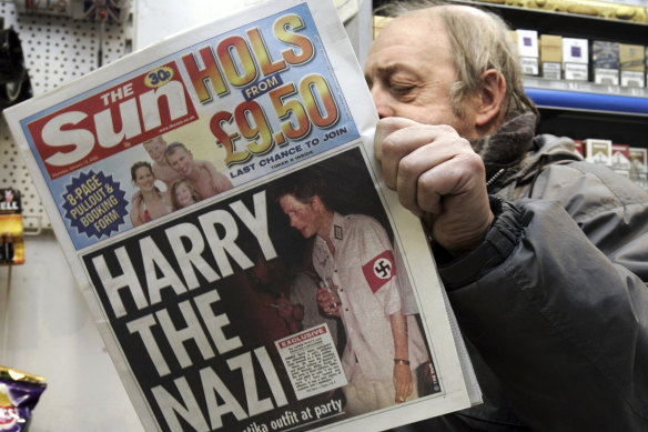 London newsagent Roy Ottoway reads a copy of tabloid ‘The Sun’, whose front page shows Prince Harry wearing a Nazi soldier’s uniform to a fancy dress party in 2005.