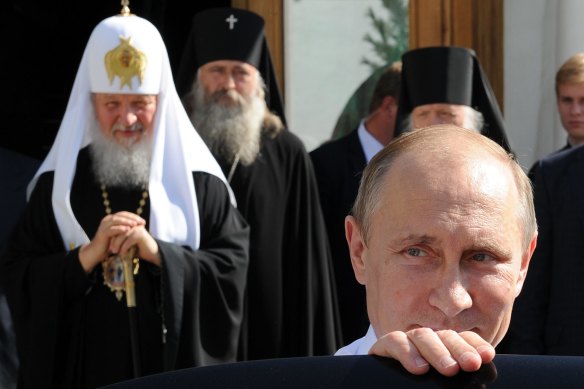 Russian President Vladimir Putin, front, leaves after his meeting with Russian Orthodox Patriarch Kirill, left, in Moscow in 2014.