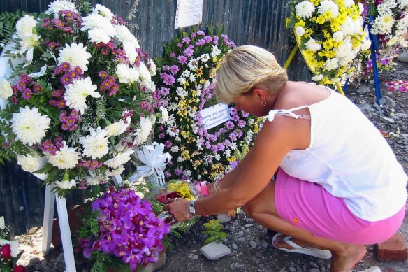 An unidentified foreign woman lays wreath at the Octotber12 bombings site in Kuta, Bali, in 2003.