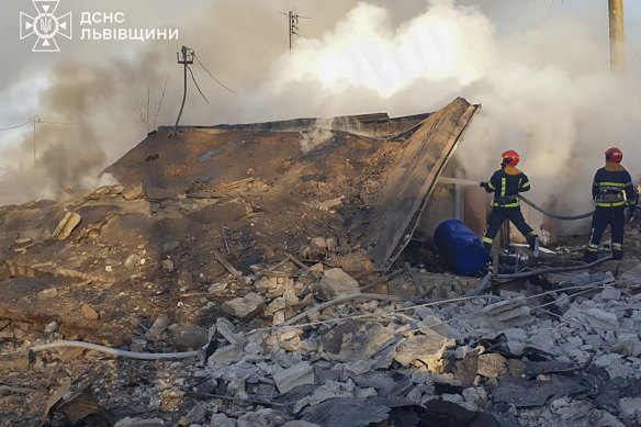 In this photo provided by the Ukrainian Emergency Service, emergency services workers extinguish a fire following a Russian rocket attack in Lviv, Ukraine, on Sunday, November 17.