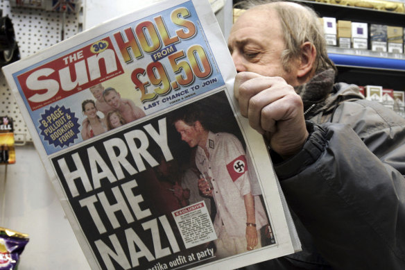 A London newsagent reads a copy of tabloid The Sun in 2005. The front page shows Prince Harry wearing a Nazi soldier’s uniform to a fancy dress party.