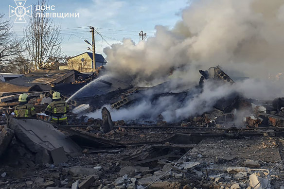 In this photo provided by the Ukrainian Emergency Service, emergency services personnel work to extinguish a fire following a Russian rocket attack in Lviv, Ukraine, on Sunday.