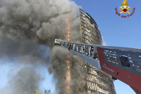 Smoke billows from a 20-storey apartment building on fire in Milan in northern Italy on Sunday.
