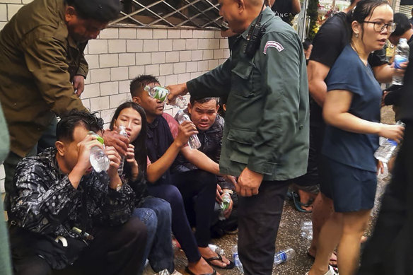 Victims receive water from police officers near a Cambodia-Thai international border gate in Poipet, west of Phnom Penh, Cambodia.