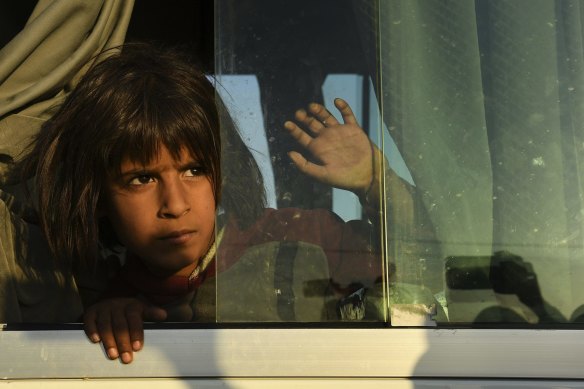 A young Syrian girl peers out the window of one of the buses bringing people to the Bardarash camp in October.