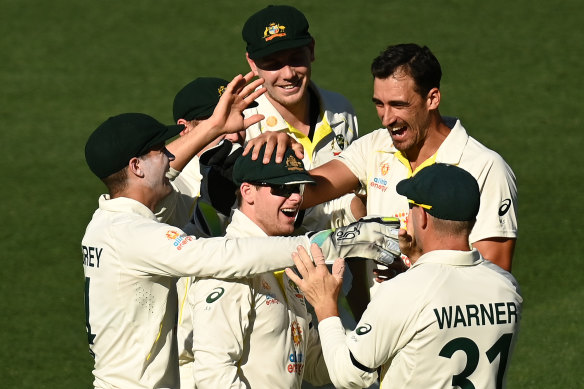 Mitchell Starc (right) celebrates one of his four wickets in England’s first innings.