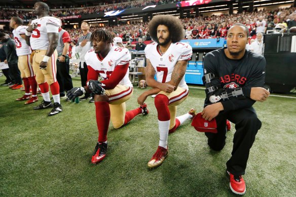 Taking a knee to make a stand: San Francisco 49ers quarterback Colin Kaepernick, centre, kneels during the playing of the US national anthem before an NFL game in 2016. 