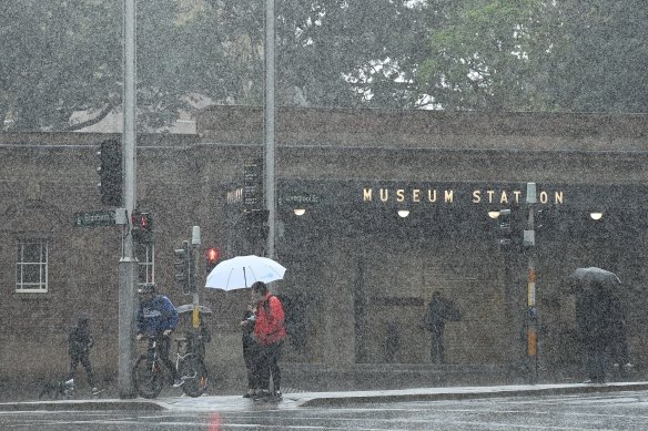 People trying to take shelter from the rain in Sydney last month.