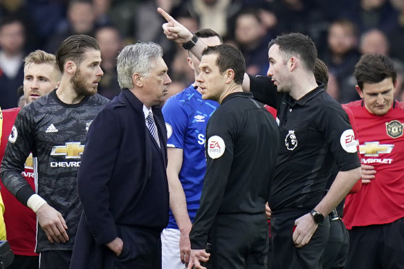 Referee Christopher Kavanagh sends Everton's manager Carlo Ancelotti off after showing him a red card.
