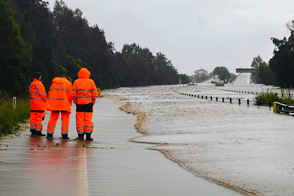 SES volunteers survey flooded roads.