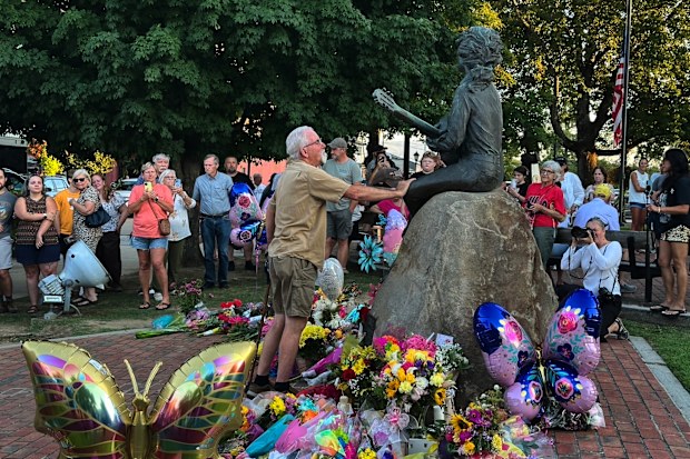 James A. Gambrell, a former chef at Dollywood, touches the Dolly Parton statue in downtown Sevierville, Tenn., on Tuesday, Aug. 25, 2026. (AP Photo/Dylan Lovan)