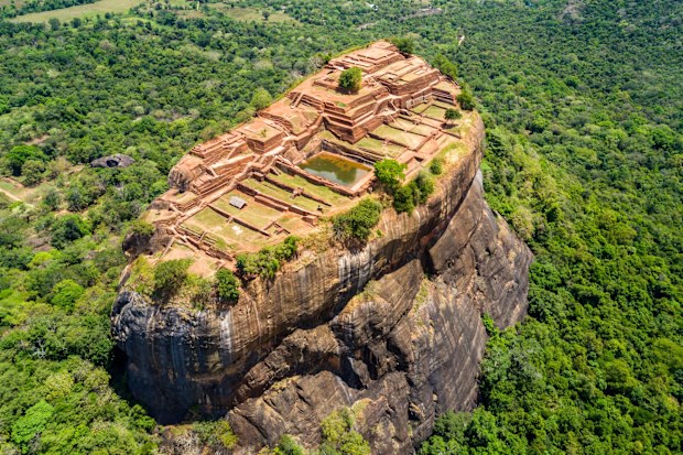 Aerial view from above of Sigiriya or the Lion Rock, an ancient fortress and a palace with gardens, pools, and terraces atop of granite rock in Dambulla, Sri Lanka. 