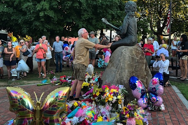 James A. Gambrell, a former chef at Dollywood, touches the Dolly Parton statue in downtown Sevierville, Tenn., on Tuesday, Aug. 25, 2026.