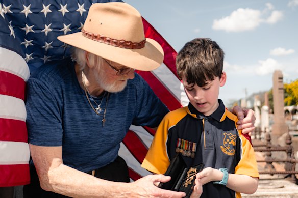 Mark Lawrence, left, a custodian of American Civil War soldier Harry Lane’s relics, gave them to Lane’s descendants including William Blake-Lane, 11, at Lane’s grave at Brighton Cemetery on Tuesday.