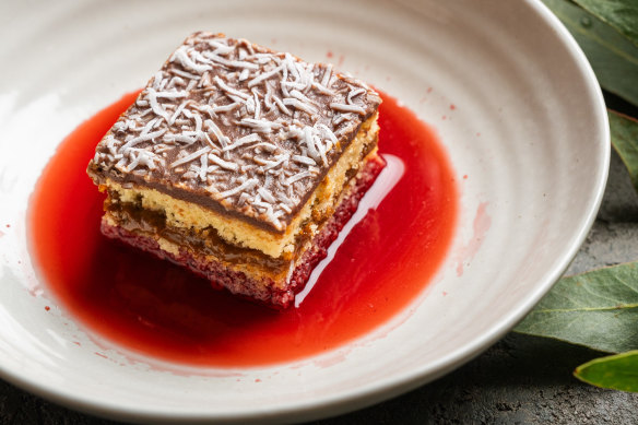 Asado’s take on a lamington includes strawberry consomme surrounding the cake.