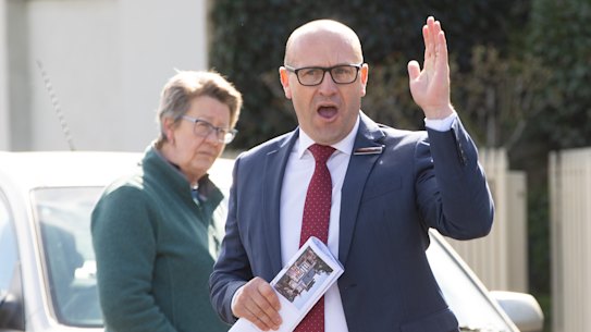 As auctioneers work the crowd, buyers are cautious to raise their hands.