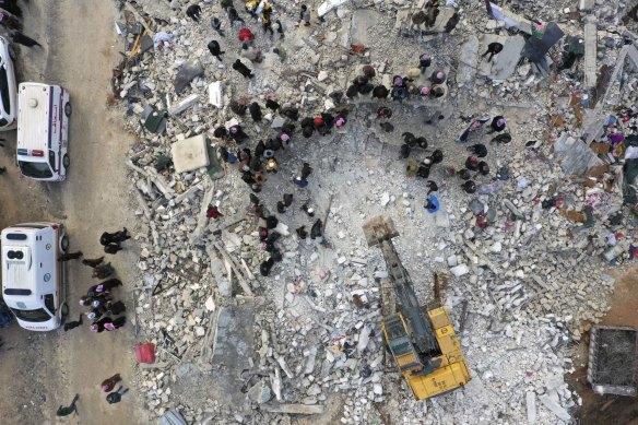 Civil defence workers and residents search through the rubble of collapsed buildings in the town of Harem near the Turkish border, Idlib province.