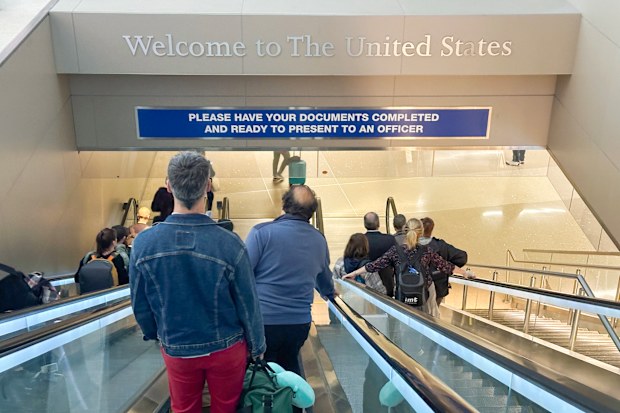 Los Angeles, California: May 2025- Arrivals walking towards US Customs and Border Protection at Los Angeles International Airport with a Welcome to The United States sign.