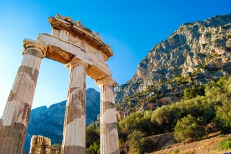 A greek temple at the base of a mountain range sundec8greece Greece ancient Olympia Peloponnese region Olympics ; text by Steve McKenna ; iStock *** REUSE PERMITTED ***Â 