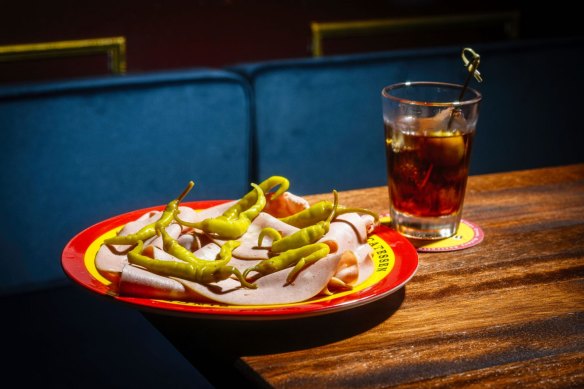 A plate of mortadella and pickles paired with sweet vermouth.