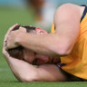 Adelaide’s Mark Keane holds his head after being concussed by Port’s Sam Powell-Pepper.