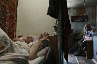 83 yaşındaki Maria Kruglova, yatalak ve Lozova'daki ev ve bahçelerindeki çöpleri temizleyen oğlu Sergei Kruglova tarafından bakılıyor.  Kapı komşusu, Rus topçu saldırılarının evini yıkması sonucu öldürüldü. 