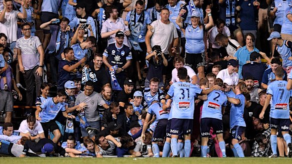 Fall season: Sydney fans sprawl onto the turf after the fence collapsed during celebrations for Cam Devlin's late sealer.