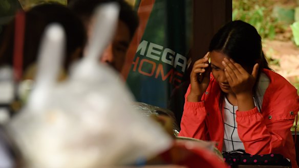 A relative reacts whilst taking a phone call at cave base camp on Saturday.