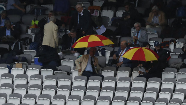 Spectators shelter under umbrellas as rain falls on day one of the 2nd Ashes Test.