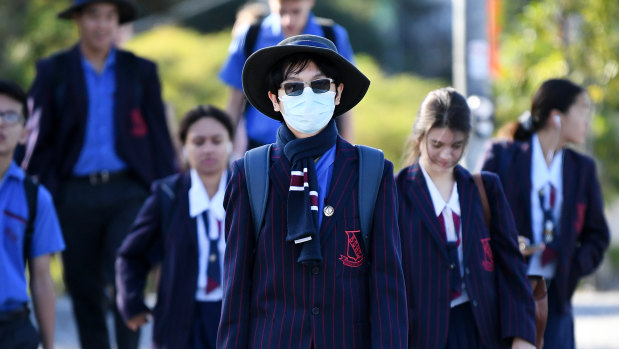 A school student wears a surgical mask as he returns to the classroom. 