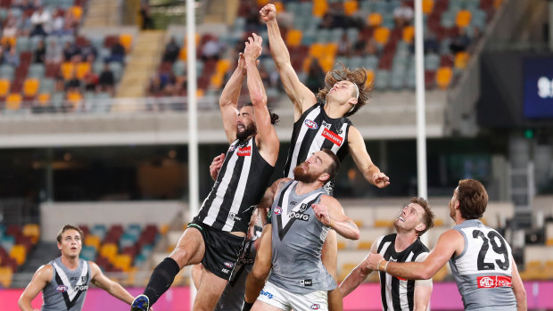 Off centre: Brodie Grundy (left) goes up in a contest with teammate Darcy Moore and Port Adelaide's Charlie Dixon.