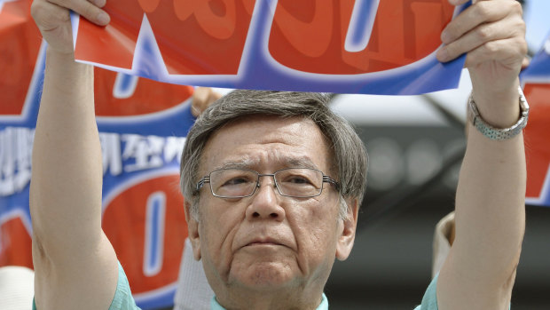 Then Okinawa Governor Takeshi Onaga shows off a banner reading 'No, new US base at Henoko', during a rally in 2015. He died of cancer last week. 