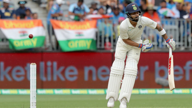 Taking one for the team: Kohli is struck during a barrage from Australia's pace trio.