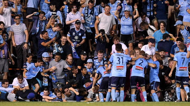 Fall season: Sydney fans sprawl onto the turf after the fence collapsed during celebrations for Cam Devlin's late sealer.