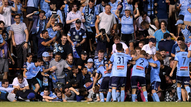 Fall season: Sydney fans sprawl onto the turf after the fence collapsed during celebrations for Cam Devlin's late sealer.