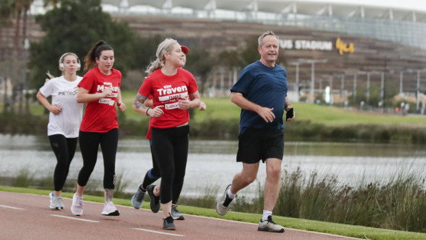 Opposition Leader Bill Shorten runs past the new Optus Stadium during a campaign stop in Perth.
