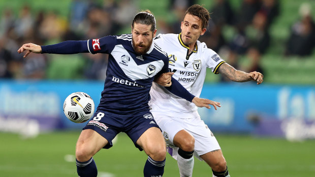 Jacob Butterfield of the Victory challenged by Matt Derbyshire of Macarthur FC during their A-League clash at AAMI Park.