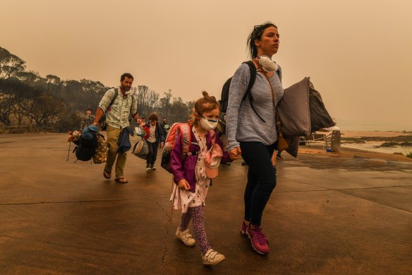 Smoke-smeared and exhausted, people prepare to leave Mallacoota.