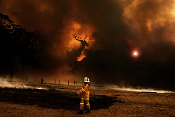 The 'Elvis' water-bombing helicopter dumps water on fires near Braemar during the 2019-20 bushfire season.
