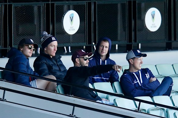 Will Pucovski (back left) and Glenn Maxwell (centre) support their Victorian teammates at the MCG on Sunday. 