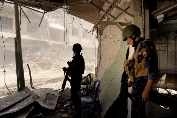 Iraqi soldiers at a street where six IEDs were yet to be cleared.