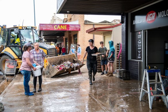 Shop owners try to clean up after floodwaters swept through the town of Molong this week.