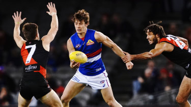 Unleashed: Essendon's Zac Clarke attempts to stop rampaging Bulldog Josh Dunkley.