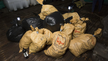 Parcels of narcotics seized by HMAS Warramunga lay on the deck of a smuggling vessel in the Middle East.